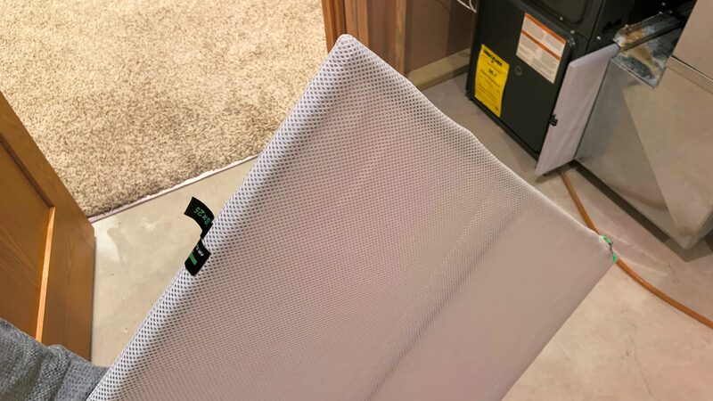 A clean panel air filter being held next to an air-handling unit